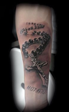 a man with a rosary tattoo on his arm