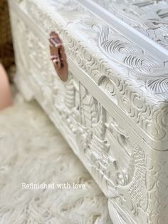 an ornately carved white bed frame with decorative carvings on the top and bottom part