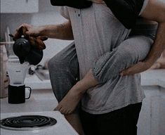 a man and woman standing next to each other in front of a stove