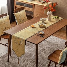 a dining room table is set with place mats, plates and bowls on the table