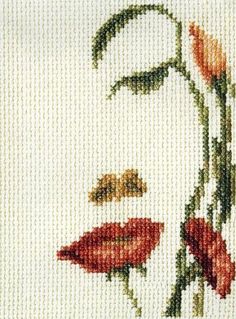 a cross stitch picture of a woman's face with flowers