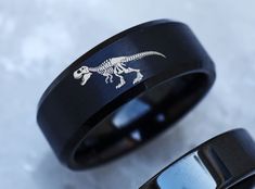 two black rings with an image of a dinosaur on them