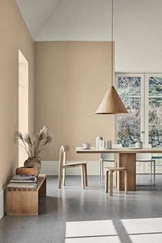 a dining room table and chairs in front of large windows with lots of natural light