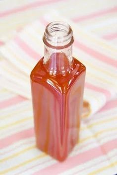 a bottle of watermelon syrup sitting on top of a pink and yellow striped table cloth