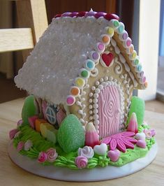 a gingerbread house decorated with icing and sprinkles on a table