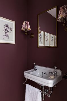 a white sink sitting under a bathroom mirror next to a wall mounted faucet