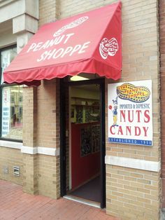 a store front with a red awning on the door and sign for peanut shoppe