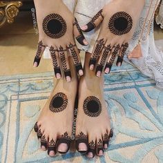 two feet with hendi designs on them and one foot has an intricate design in the middle