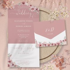 wedding stationery with pink flowers and white envelopes on a plate next to dried flowers