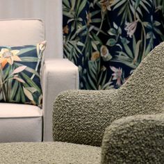 a living room filled with furniture next to a flowered wallpaper covered window curtain