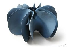 a blue sculpture is shown on a white surface