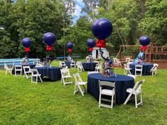 an outdoor party with blue and red balloons