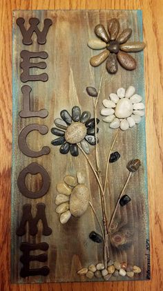 a wooden table topped with a metal plaque covered in flowers and leaves on it's side