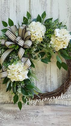 a wreath with white flowers and green leaves