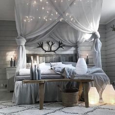 a bed room with a neatly made bed and some lights on the wall above it