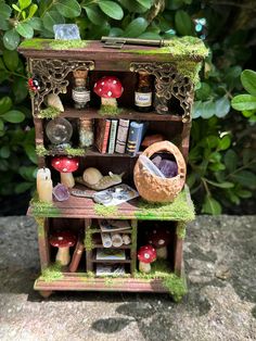 a miniature book shelf filled with lots of books and other things on top of it