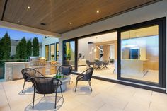 an outdoor kitchen and dining area with patio furniture