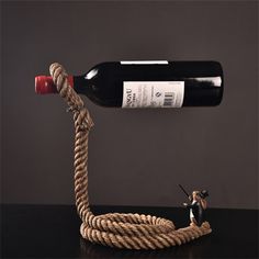 a rope connected to a wine bottle with a figurine on the top one