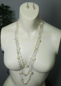 An abstract silver chain is strung to clear beads and brushed cream pearls to form this lovely set. Featuring unique diamond silver chain details and clear gems that are plated around the crystal! These two pieces are magnificent and are sure to stand out! Handmade and supports future art! Pearl Beaded Chain Dangle Jewelry, Party Jewelry With Pearl Beaded Chain, Elegant Crystal Necklace With Pearl Chain, White Crystal Necklace With Silver Beads, Elegant Sparkling Metal Necklaces, Elegant Sparkling Metal Necklace, Clear Metal Jewelry For Party, Sterling Silver Jewelry With Pearl Charm For Party, Sterling Silver Pearl Chain Jewelry For Party