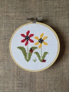 a cross stitch pattern with three flowers in it on a piece of fabric that has been sewn together