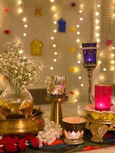 a table topped with candles and flowers next to other items on top of a table