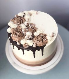 a white cake with chocolate icing and flowers on top