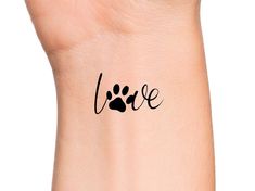 a wrist tattoo with the word love written in black ink on it's left arm