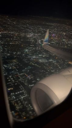 the wing of an airplane flying over a city at night