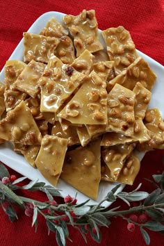 a white plate topped with ravioli covered in peanut butter sauce and chopped walnuts