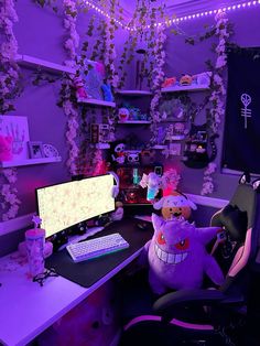 a desk with two computers and stuffed animals on it