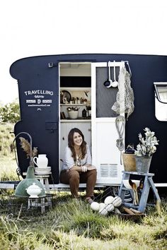 a woman sitting in the doorway of a trailer