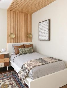 a bed sitting next to a dresser in a bedroom on top of a wooden floor