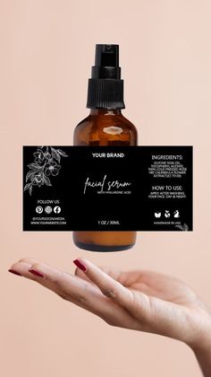 a hand holding up a bottle of facial spray with a business card attached to it