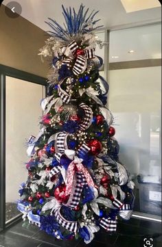 a christmas tree decorated with red, white and blue ribbons