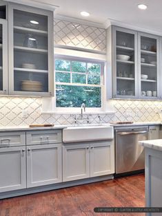 a kitchen with gray cabinets and white counter tops