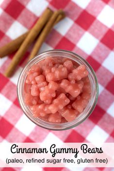 cinnamon gummy bears in a glass jar on a red and white checkered tablecloth