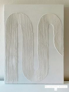 the letter u is made out of white paint and has wavy lines on it's surface