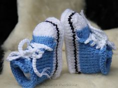 a pair of blue and white crocheted baby shoes