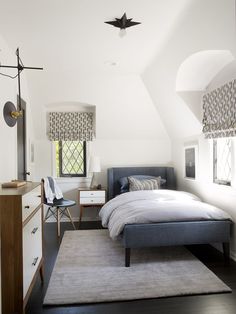 a bedroom with white walls and black floors