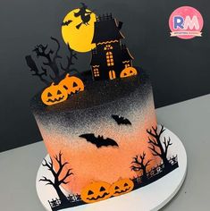 there is a cake decorated to look like a house with bats and pumpkins on it