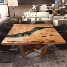 a wooden table sitting inside of a living room next to couches and tables with chairs around it