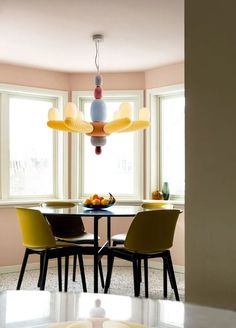 a dining room table with four chairs and a chandelier hanging from the ceiling