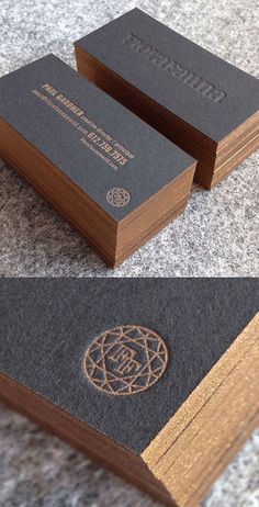 two different business cards on the ground, one is black and brown with gold trim