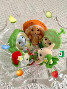 a glass bowl filled with small stuffed animals