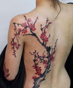 the back of a woman's body with tattoos on it