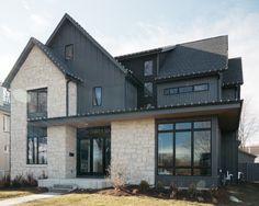 the front of a large house with lots of windows and stone sidings on it