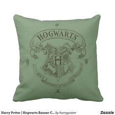 a green harry potter pillow with hogwart's crest on it