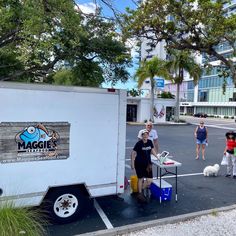 people are standing in the parking lot next to a food truck