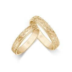 two gold wedding bands with intricate designs on each band, set against a white background