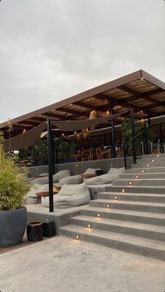 an outdoor seating area with concrete steps leading up to the roof and lights on the stairs